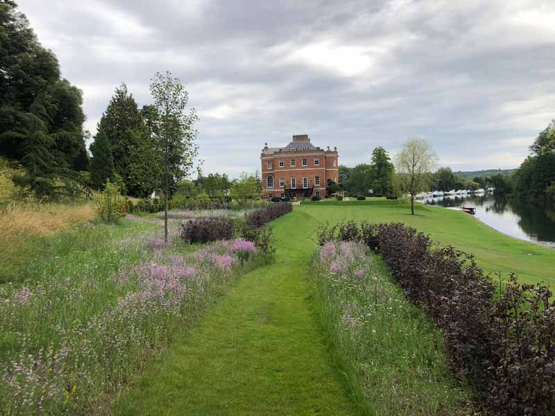 large garden with lawns and wildflower meadows running down towards the River Thames